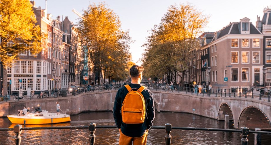 junger Mann schaut auf Gracht, © GettyImages, Alexander Spatari_