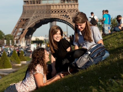 Three young women on lawn in front of Eiffel Tower, © Alan Bailey